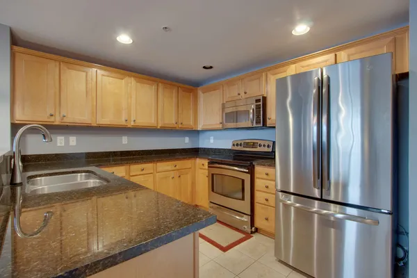 a kitchen with stainless steel appliances granite countertop a refrigerator sink and microwave