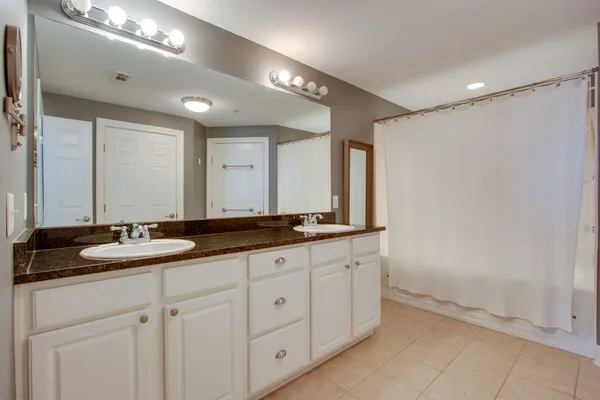 a bathroom with double sink and a mirror