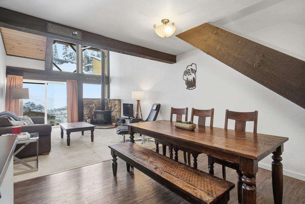 a dining room with wooden floor a glass table and chairs