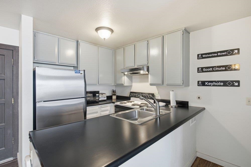 2090 Chalet Road, Unit 16 Alpine Meadows, CA 96146 - Photo 5 of 20 a kitchen with kitchen island a counter top space a stainless steel appliances a sink and refrigerator