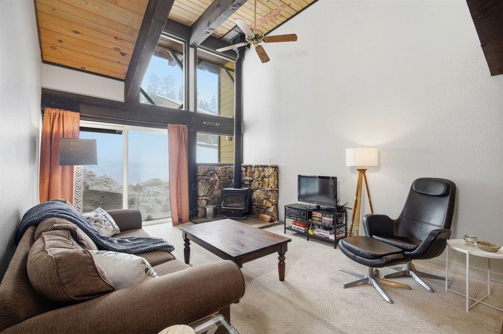 2090 Chalet Road, Unit 16 Alpine Meadows, CA 96146 - Photo 8 of 20 a living room with furniture a fireplace and a floor to ceiling window