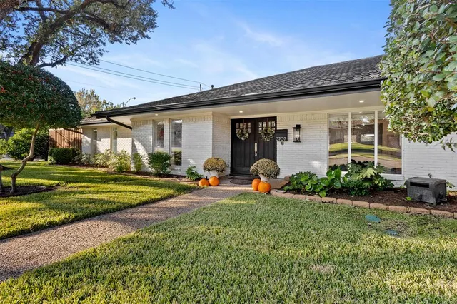 a front view of a house with garden and plants