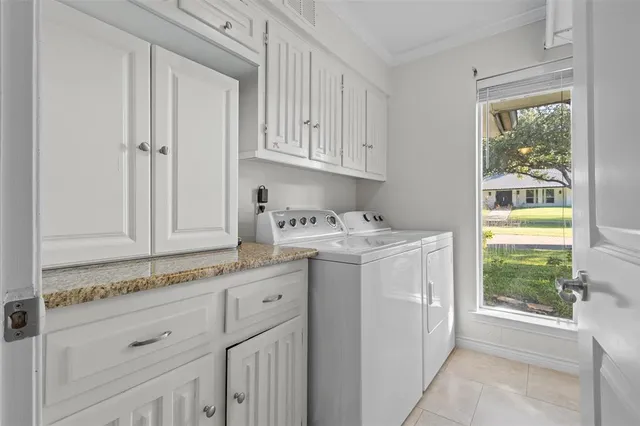 a utility room with cabinets washer and dryer