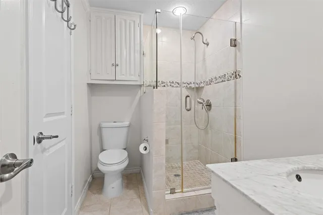 a bathroom with a granite countertop sink a toilet and shower