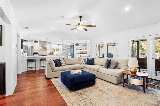 a living room with furniture kitchen view and a chandelier