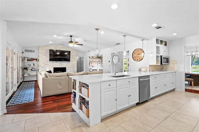 a large kitchen with stainless steel appliances granite countertop a stove and a sink