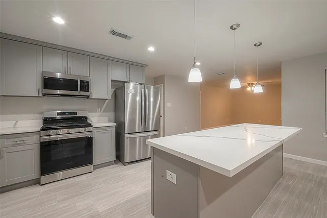 a kitchen with kitchen island a sink stainless steel appliances and cabinets