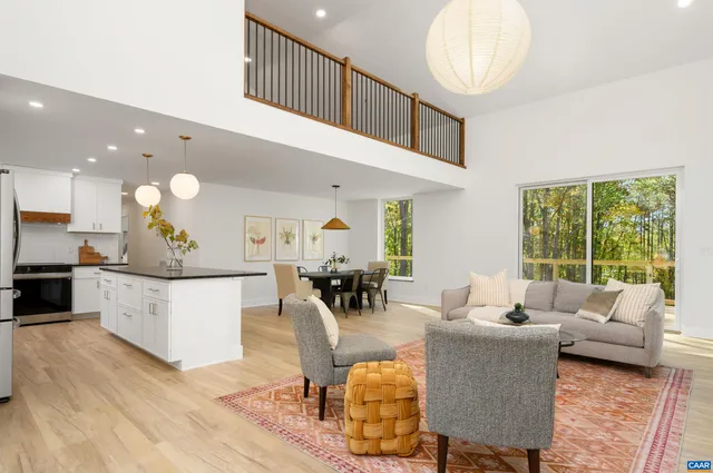 a living room with furniture kitchen view and a large window