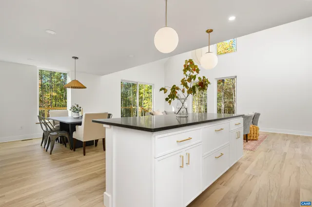 a kitchen with white cabinets and wooden floor