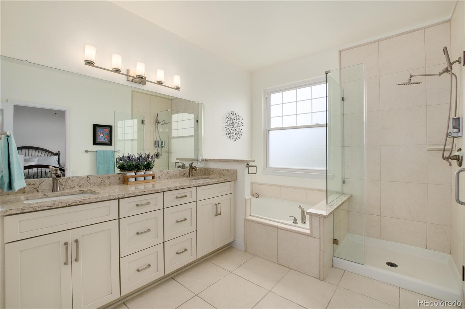 3946 Mallard Street Highlands Ranch, CO 80126 - Photo 18 of 40 a bathroom with a granite countertop sink a mirror a bathtub and shower
