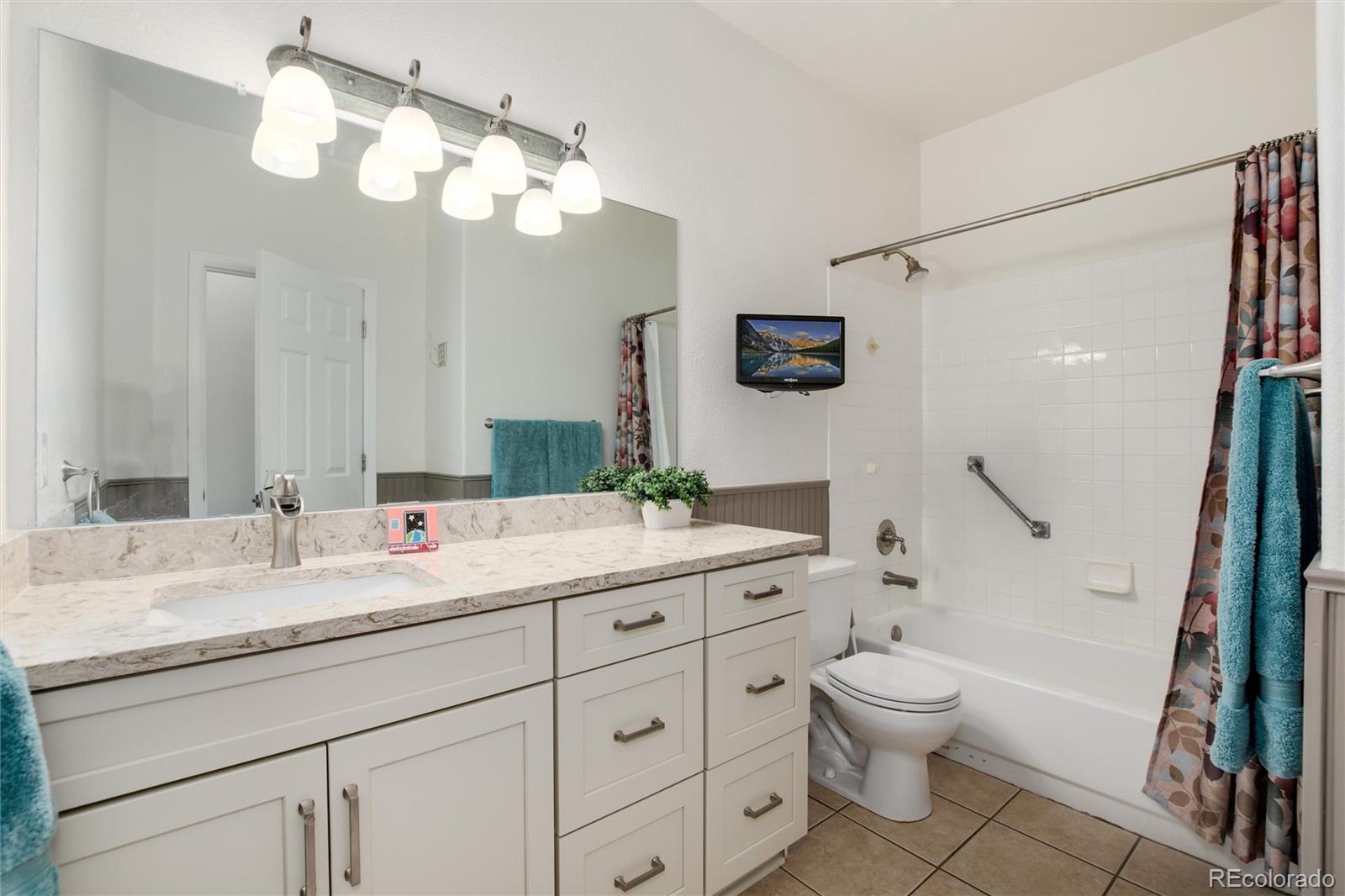 3946 Mallard Street Highlands Ranch, CO 80126 - Photo 21 of 40 a bathroom with a sink a toilet and a mirror