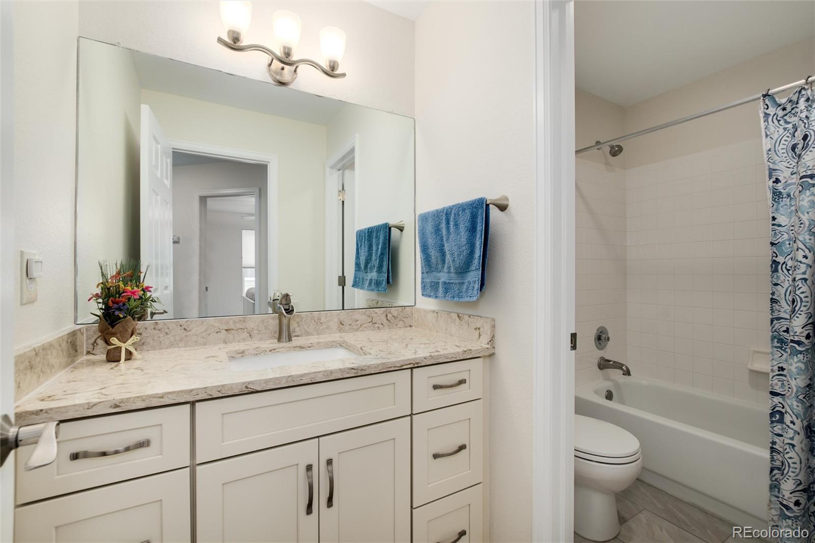 3946 Mallard Street Highlands Ranch, CO 80126 - Photo 25 of 40 a bathroom with a granite countertop sink toilet and shower