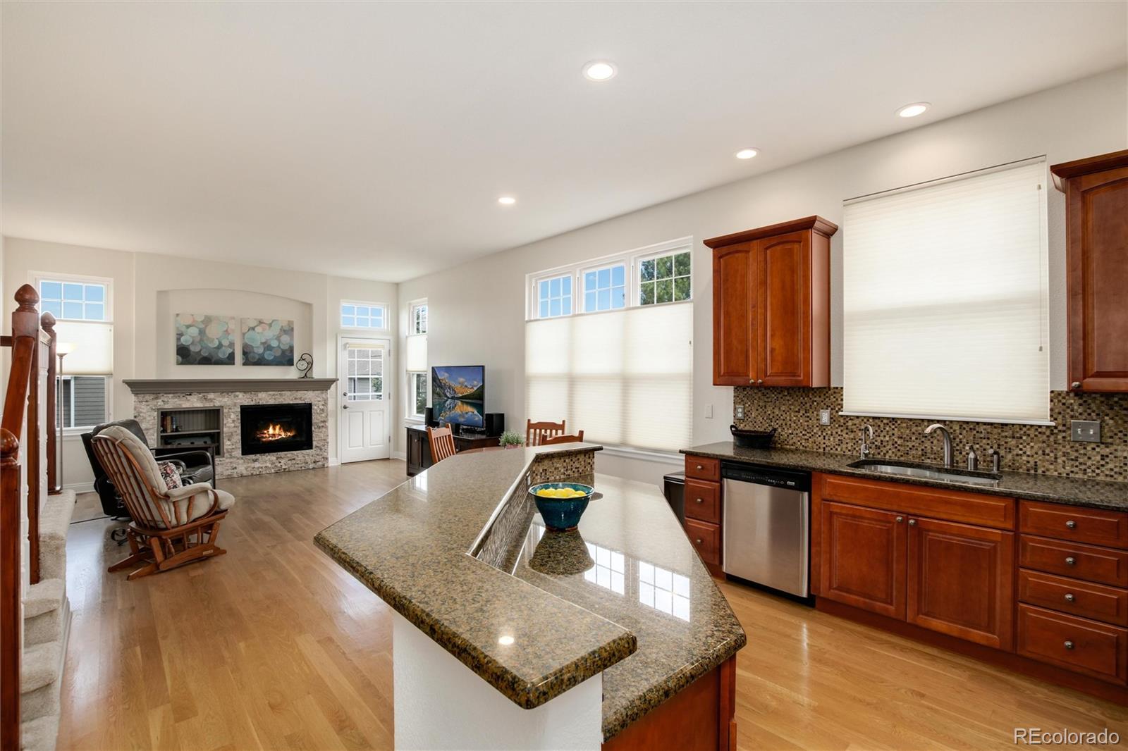 3946 Mallard Street Highlands Ranch, CO 80126 - Photo 7 of 40 a living room with furniture a fireplace a flat screen tv and a window