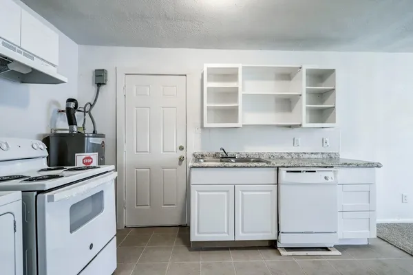 a kitchen with white cabinets and appliances