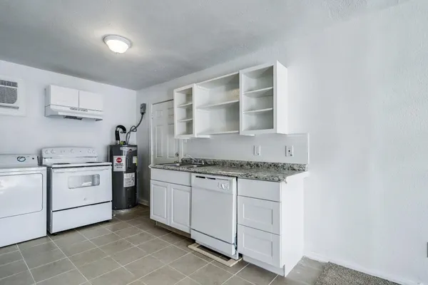 a kitchen with white cabinets and white appliances