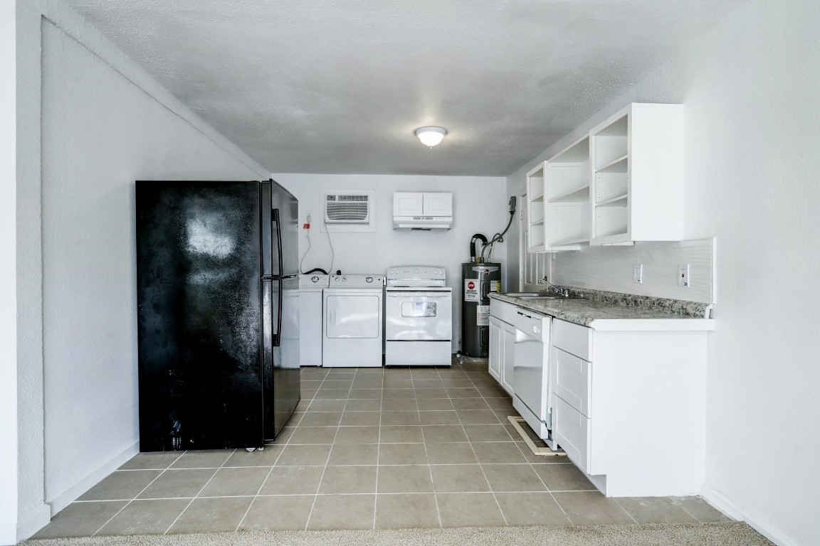 3823 Lydia Street Houston, TX 77021 - Photo 9 of 18 a kitchen with granite countertop a refrigerator and a stove top oven