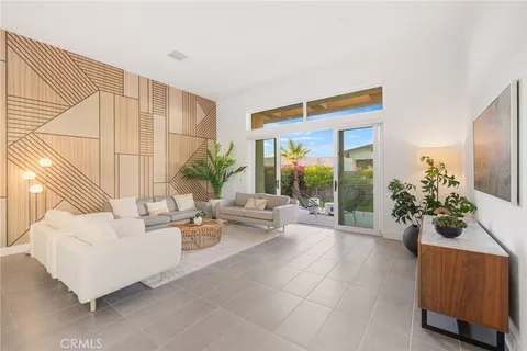 a living room with furniture kitchen view and a large window