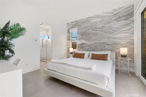 a room with a bed and a potted plant
