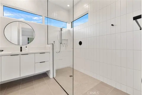 a bathroom with a double vanity sink mirror and shower