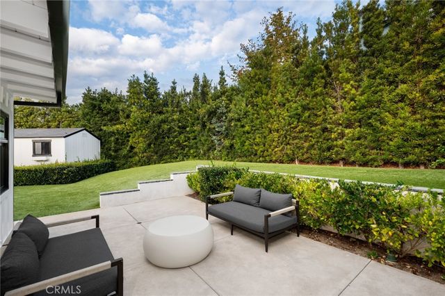 a view of a patio with couches and a table and chairs with wooden fence