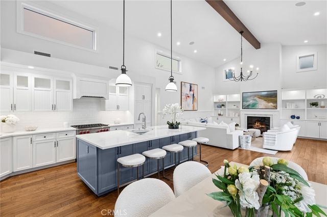 a large kitchen with kitchen island stainless steel appliances a stove a sink a center island and furniture