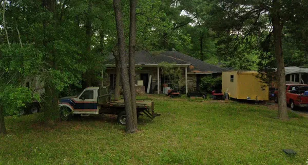 a view of a chair and table in backyard of the house