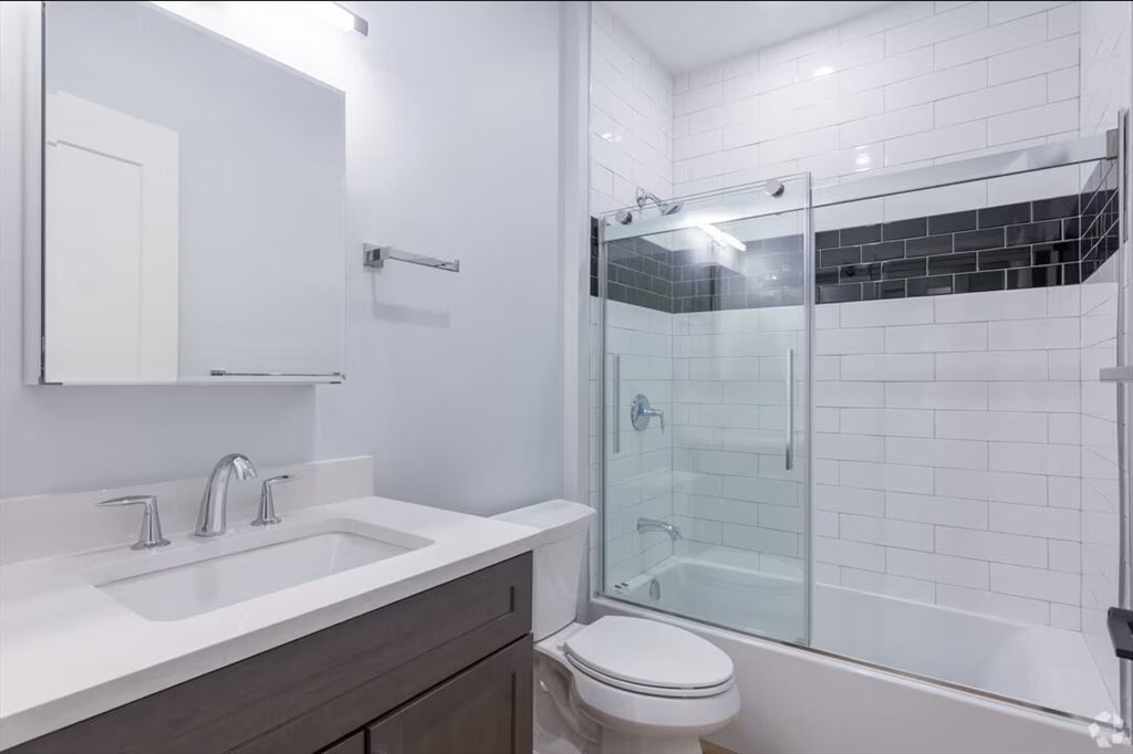 a bathroom with a sink a toilet and shower