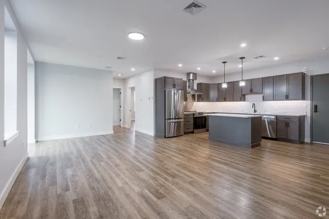 a large white kitchen with a large counter top appliances and cabinets