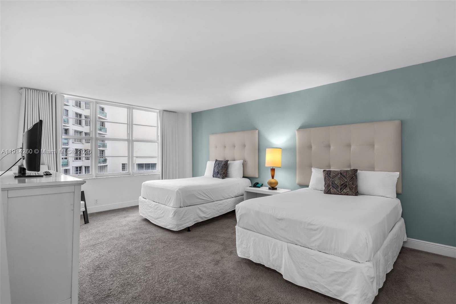 5101 Collins Avenue, Unit 12B Miami Beach, FL 33140 - Photo 7 of 13 a bedroom with bed and a large window