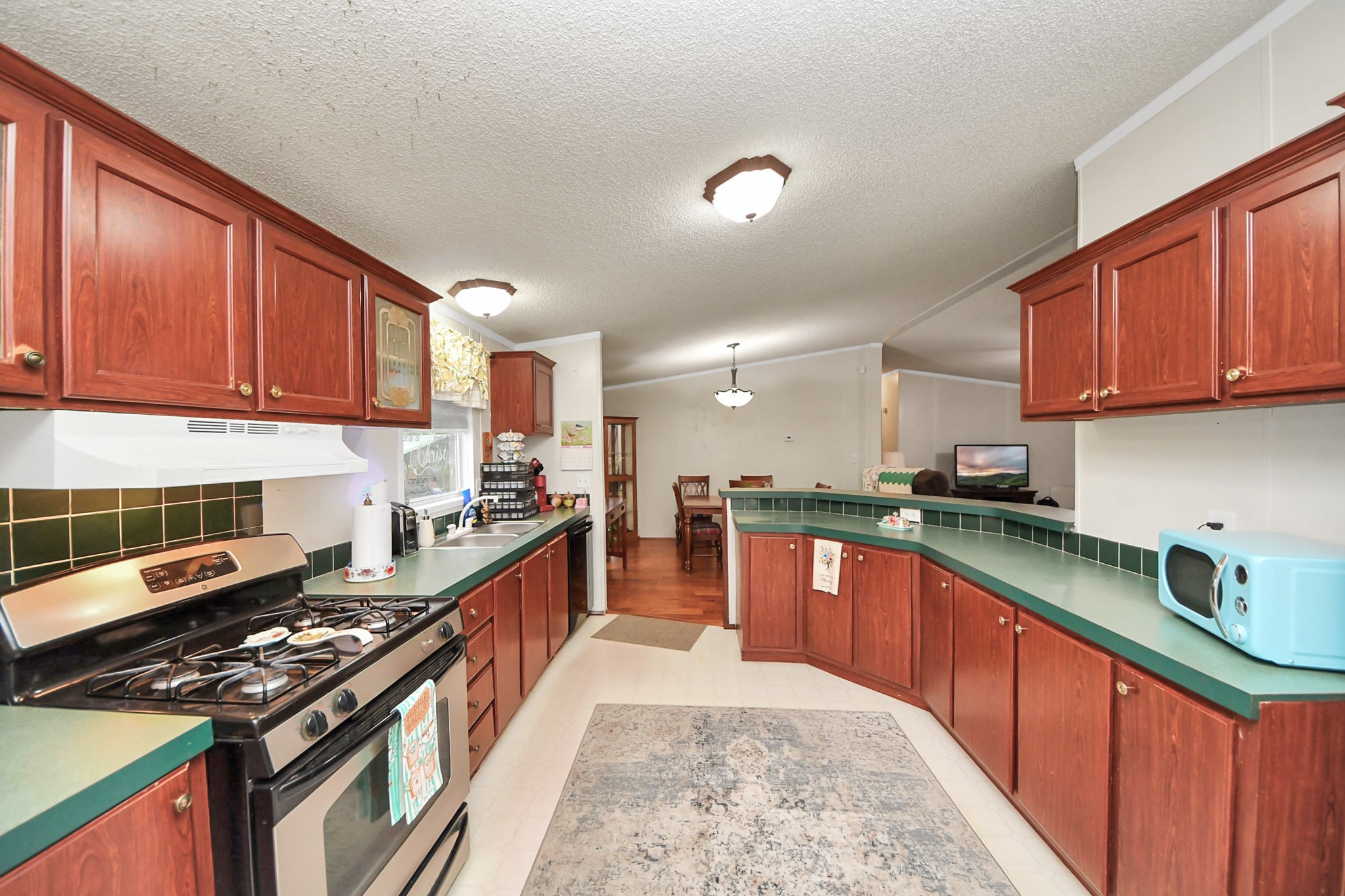 204 Edith Street Highlands, TX 77562 - Photo 20 of 33 a kitchen with stainless steel appliances granite countertop a stove a sink dishwasher and a microwave oven with cabinets