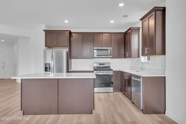 a kitchen with stainless steel appliances granite countertop a refrigerator sink and stove
