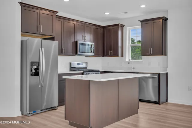 a kitchen with stainless steel appliances granite countertop a refrigerator and a sink