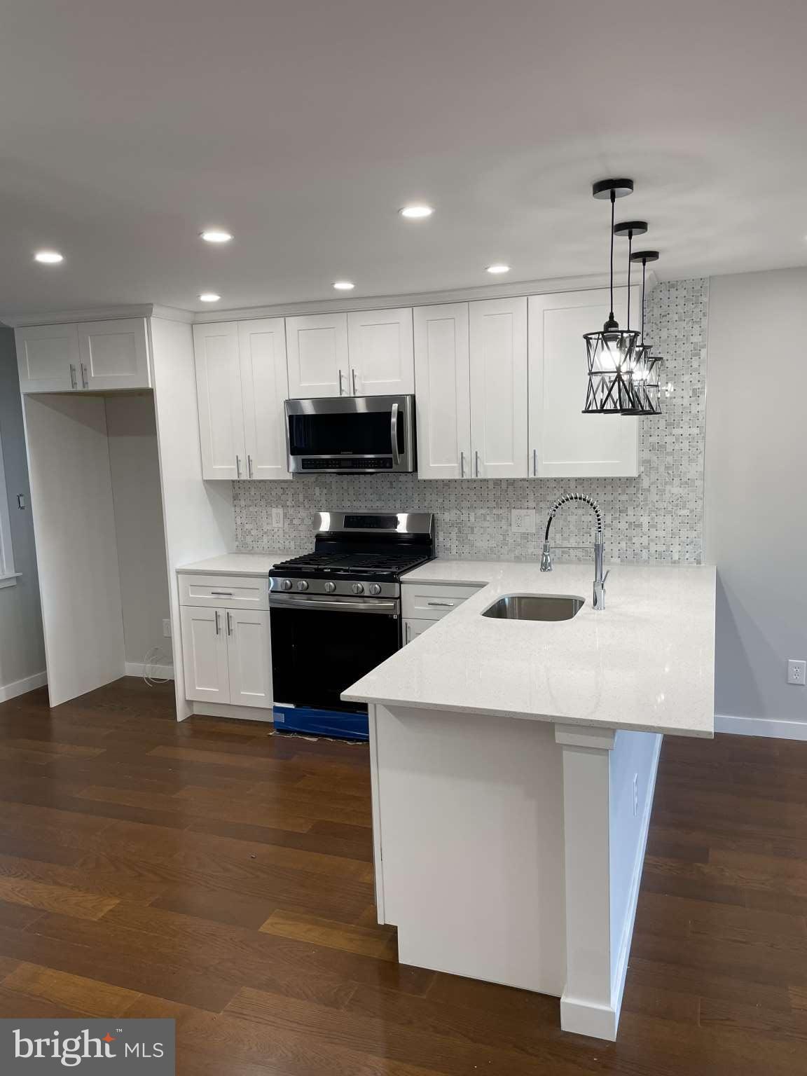 1305 Elson Road Brookhaven, PA 19015 - Photo 8 of 9 a kitchen with kitchen island a sink stainless steel appliances and cabinets