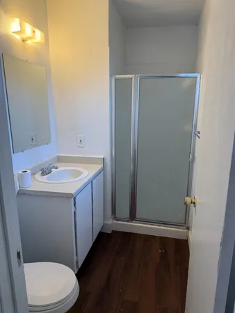 a bathroom with a sink a toilet and shower