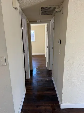 a view of a hallway with wooden floor and staircase