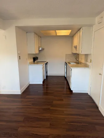 a kitchen with granite countertop wooden floors and white stainless steel appliances