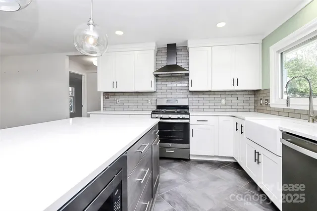 a kitchen with stainless steel appliances a stove sink and cabinets