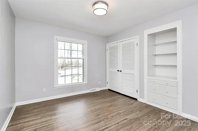 an empty room with wooden floor and window