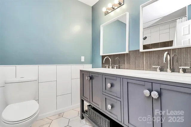 a bathroom with a toilet a sink and mirror