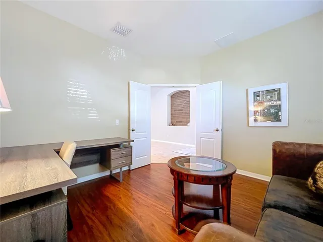 a kitchen with stainless steel appliances granite countertop a stove top oven a sink dishwasher a dining table and chairs with wooden floor