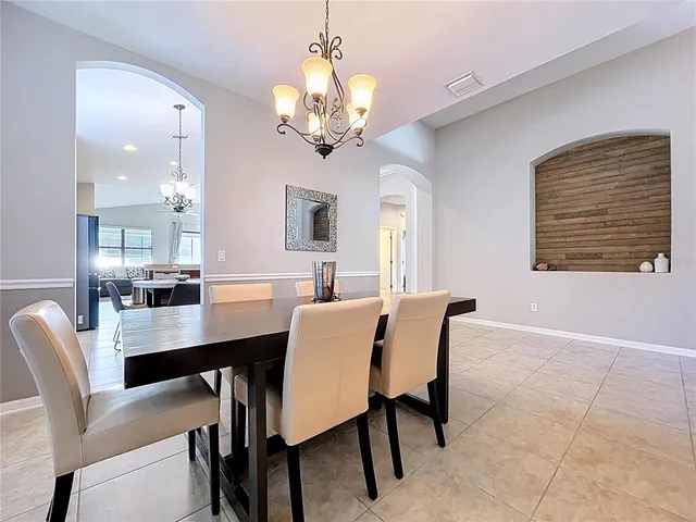 a view of a dining room with furniture and a chandelier