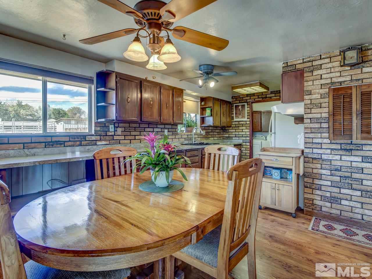 11495 Carlsbad Road Reno, NV 89508 - Photo 8 of 25 a dining room with furniture a floor to ceiling window and wooden floor