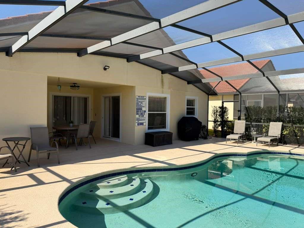 328 Robin Road Davenport, FL 33896 - Photo 16 of 17 a view of a backyard with dining table and chairs under an umbrella