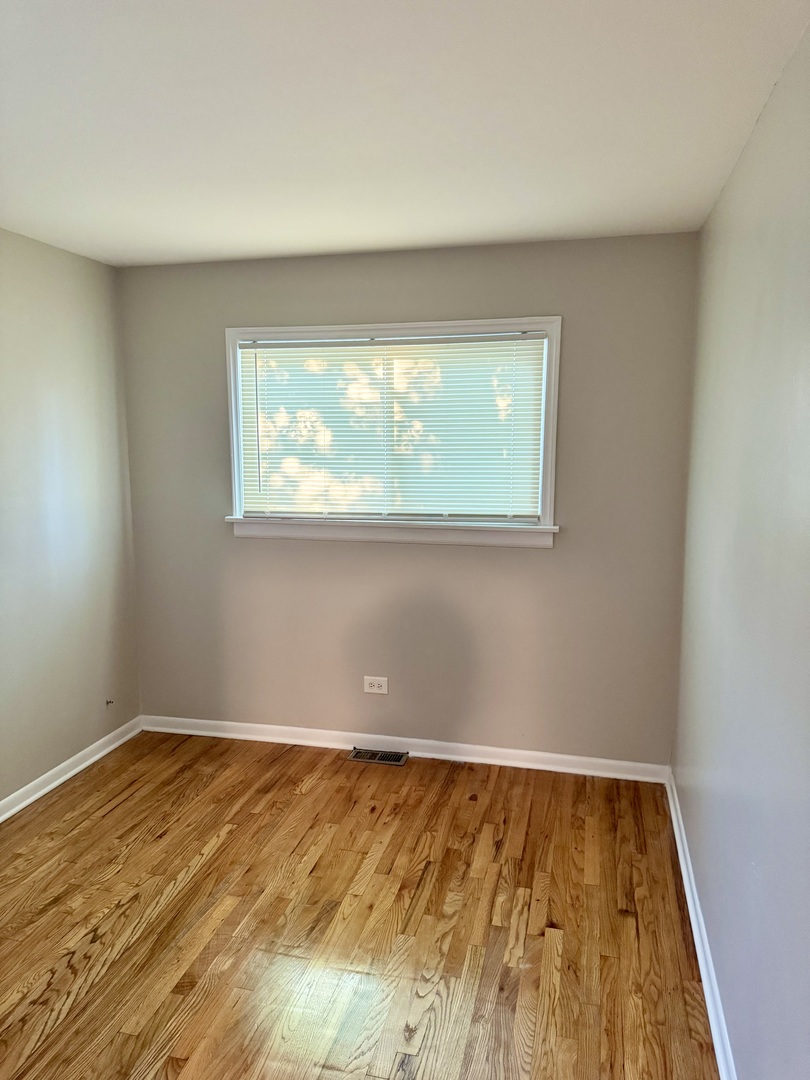 16919 Western Avenue Hazel Crest, IL 60429 - Photo 11 of 21 an empty room with wooden floor and windows