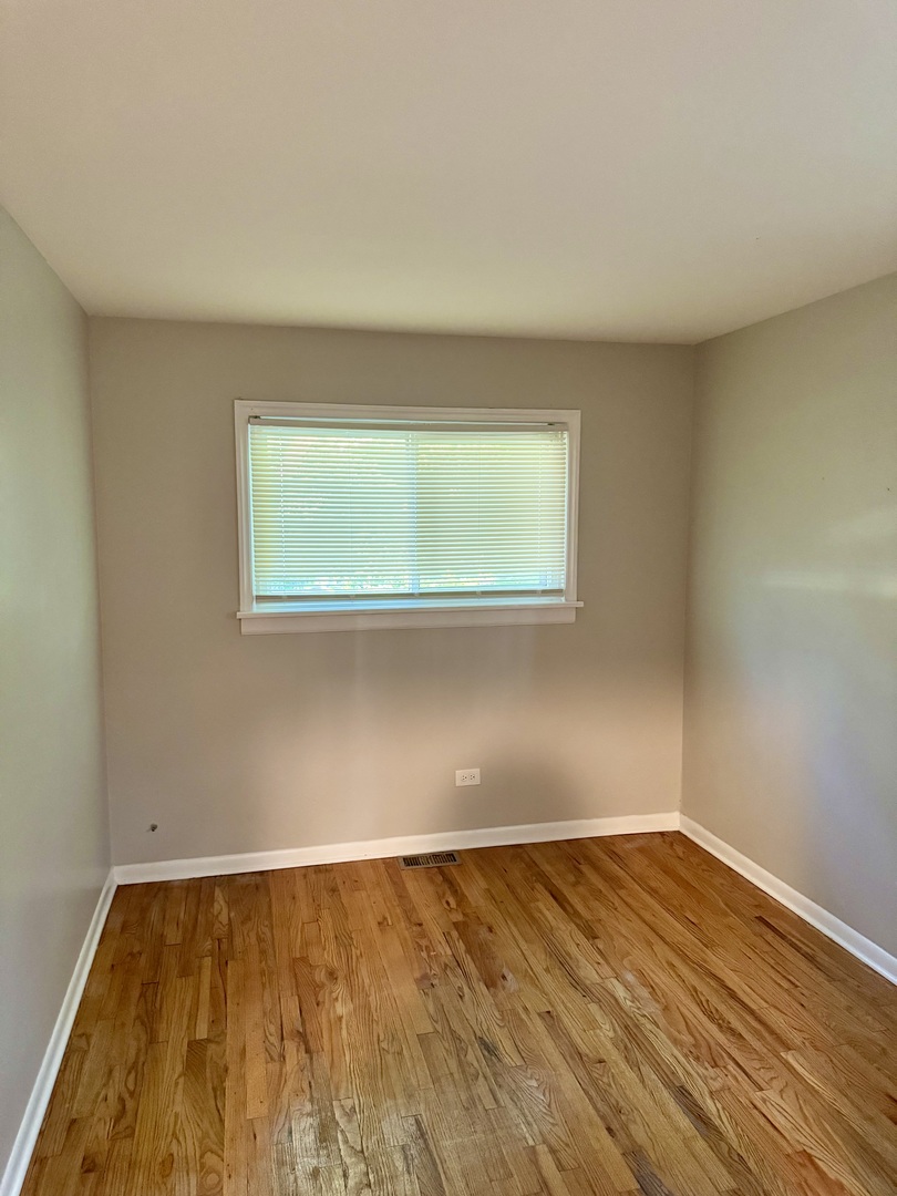 16919 Western Avenue Hazel Crest, IL 60429 - Photo 15 of 21 a view of an empty room with wooden floor and a window