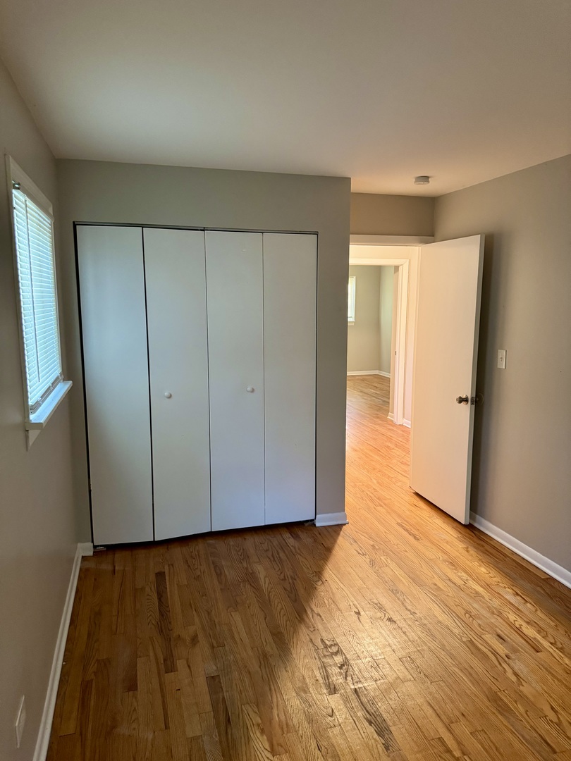 16919 Western Avenue Hazel Crest, IL 60429 - Photo 16 of 21 a view of an empty room with wooden floor and a window