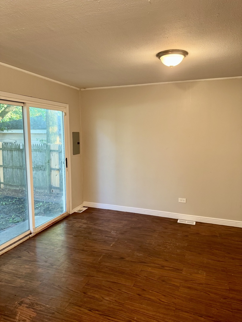 16919 Western Avenue Hazel Crest, IL 60429 - Photo 6 of 21 a view of an empty room with wooden floor and a window