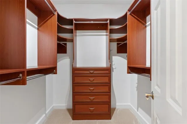 a view of a hallway with wooden floor and a bathroom