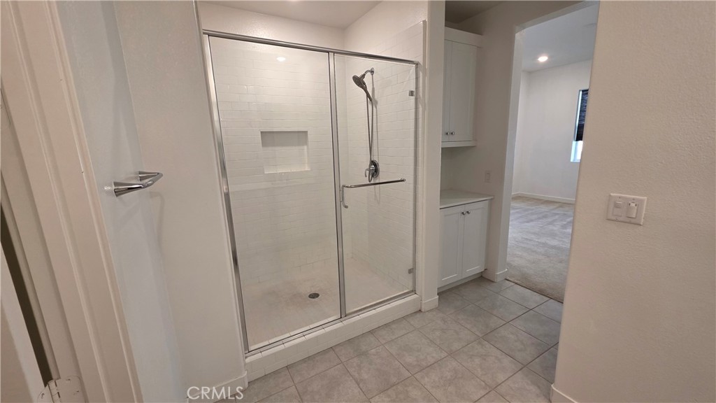 26955 West Prospector Road, Unit 201 Valencia, CA 91381 - Photo 17 of 30 a bathroom with a glass shower door and a sink
