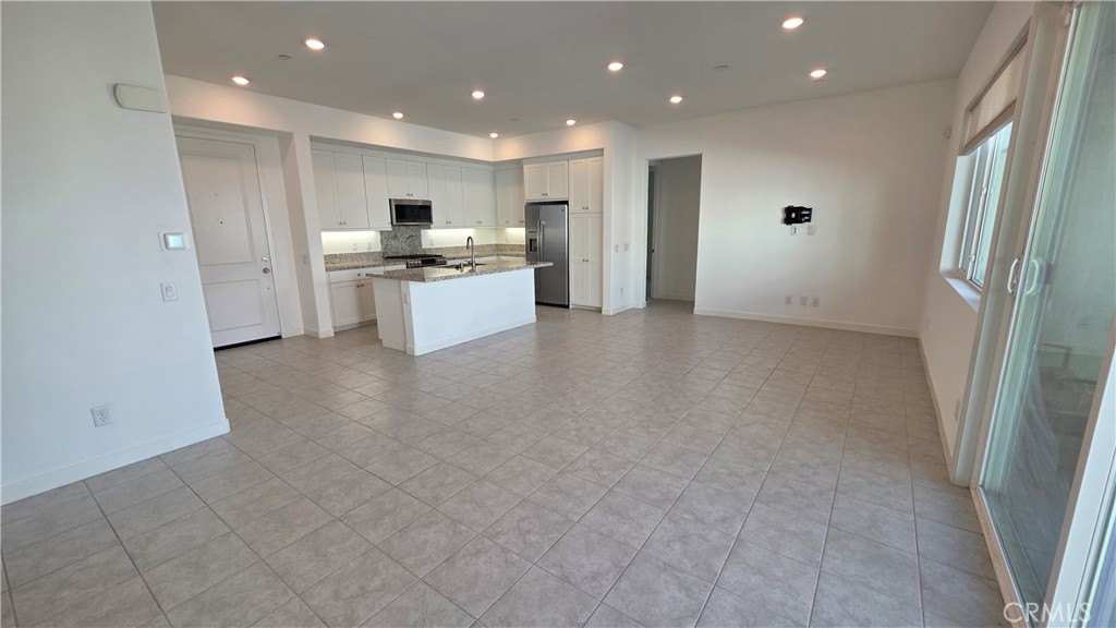 26955 West Prospector Road, Unit 201 Valencia, CA 91381 - Photo 5 of 30 a large kitchen with a refrigerator and white cabinets